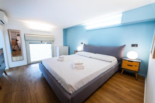 een slaapkamer met een groot bed met een blauwe muur bij Loft Porta Maggiore in Rome