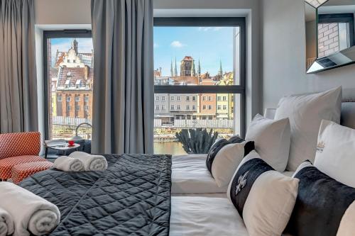 a bedroom with a bed and a large window at Deo Plaza Riverside & Radisson SPA by Downtown Apartments in Gdańsk
