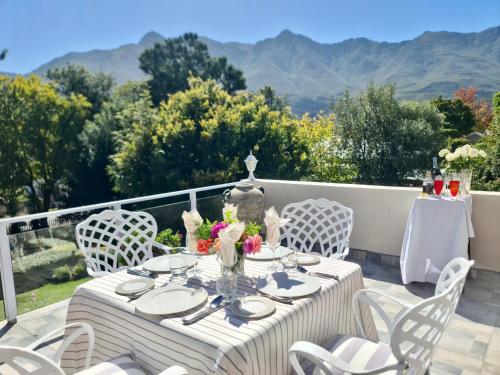 a table and chairs on a patio with mountains in the background at The View Swellendam B&B in Swellendam