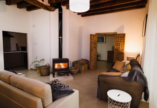a living room with two couches and a fireplace at Casa De Los Cuadros in Villaluenga del Rosario