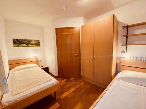 a small room with two beds and a closet at Apartments Residence Montana in Rasun di Sopra