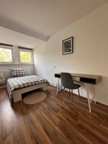 sypialnia z łóżkiem, biurkiem i stołem w obiekcie Schönes Zimmer im Zentrum - 2 w mieście Paderborn