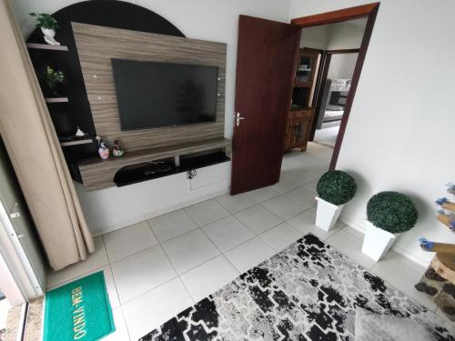 uma sala de estar com uma grande televisão de ecrã plano em Casa de Praia Balneário Piçarras em Piçarras