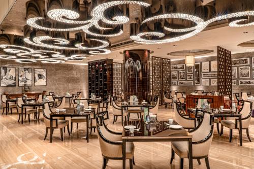 a restaurant with tables and chairs and a chandelier at Crowne Plaza Xi'an, an IHG Hotel in Xi'an