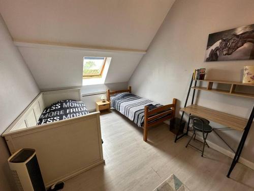 une chambre mansardée avec un lit et un bureau dans l'établissement Modern Family House near Astérix Airport Chantilly, à Orry-la-Ville