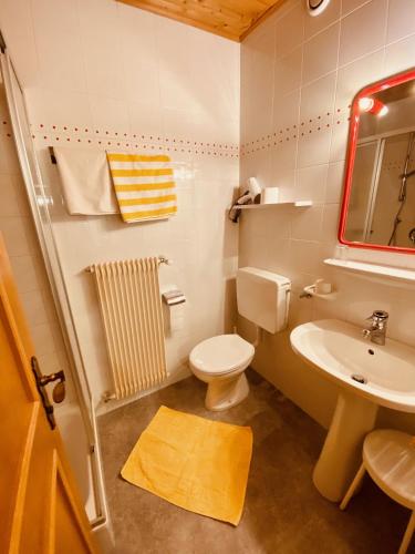 a small bathroom with a toilet and a sink at Apartments Residence Montana in Rasun di Sopra