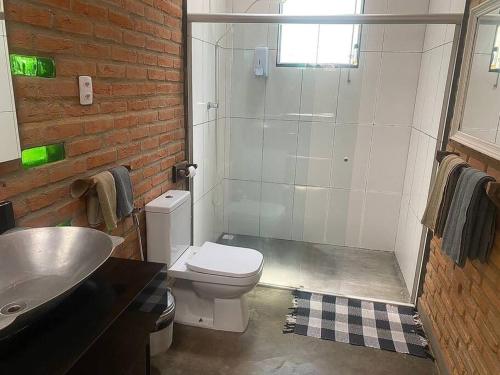 a bathroom with a shower and a toilet and a sink at Refugio do Amor in São João del Rei