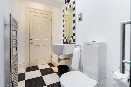Baño blanco con lavabo y aseo en Thrushley Cottage in Wakefield - sleeps 7 - with roof terrace, 
