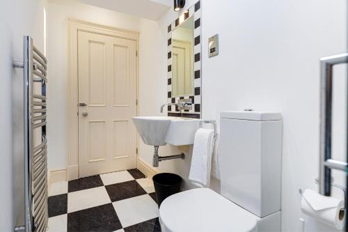 une salle de bain blanche avec un lavabo et des toilettes dans l'établissement Thrushley Cottage in Wakefield - sleeps 7 - with roof terrace, à Middlestown