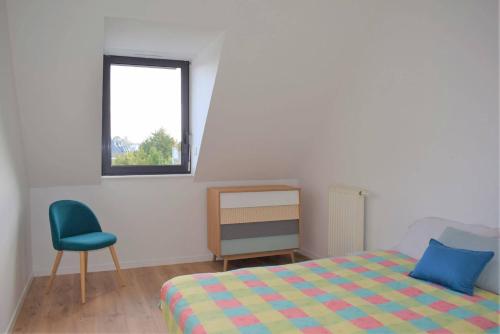 une chambre avec un lit, une chaise et une fenêtre dans l'établissement Bel appartement entièrement rénové 5 personnes au centre ville de PERROS-GUIREC - Ref 923, à Perros-Guirec