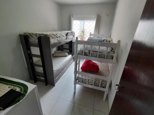 een kamer met twee stapelbedden en een raam bij Casa de Praia Balneário Piçarras in Piçarras