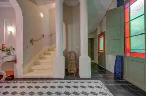 a hallway with stairs and stained glass windows at Boho Rooms Sliema in Sliema