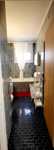 a bathroom with a toilet and a window at ApartaHotel L'escapade Urbaine in Lausanne