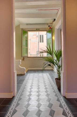 a hallway with a potted plant and a window at Boho Rooms Sliema in Sliema