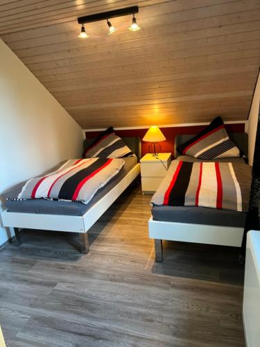 two beds in a room with wooden ceilings at 3 separate Messe Appartements bis zu 11 Personen in Ratingen
