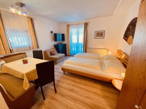 a bedroom with a bed and a table in it at Apartments Residence Montana in Rasun di Sopra