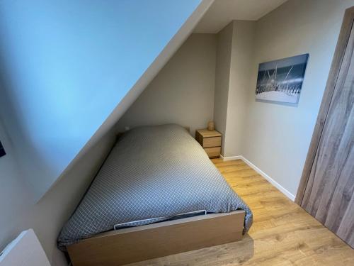 une chambre avec un lit dans le coin d'une pièce dans l'établissement Ker est, Surf House, plage de Pors Carn à pieds, à Penmarcʼh