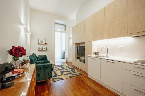 a kitchen with white cabinets and a sink and a table at Home With a Pool by Vacationy in Porto