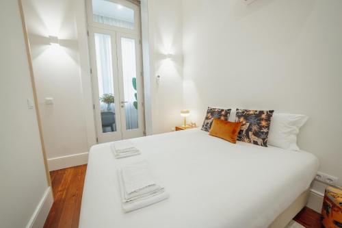a white bedroom with a large white bed and a window at Home With a Pool by Vacationy in Porto