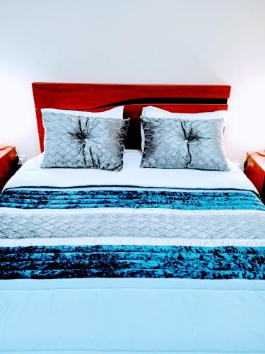 a bed with blue and white sheets and pillows at Porto Cruz House in Vila Nova de Gaia