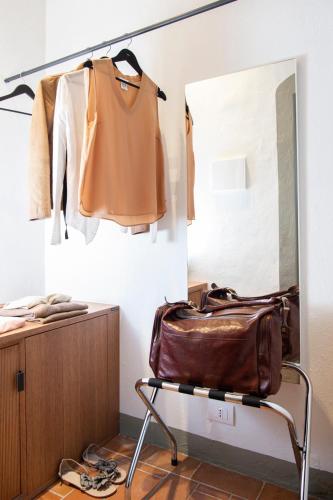 a dressing room with a brown bag and a mirror at Salvadonica in San Casciano in Val di Pesa