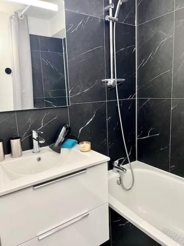 une salle de bain avec une douche, un lavabo et une baignoire dans l'établissement Perle Beach, Petite maison située en bord de plage, piscine., à Guidel