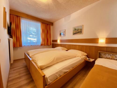 a bedroom with two beds and a window at Apartments Residence Montana in Rasun di Sopra