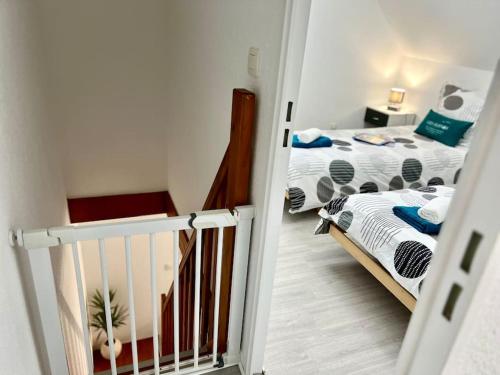 - une petite chambre avec 2 lits et un lit bébé dans l'établissement Perle Beach, Petite maison située en bord de plage, piscine., à Guidel
