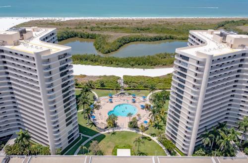 an aerial view of two tallominiums with a pool at Updated 2 Bed Condo Offering Long Beach Views From Balcony in Marco Island