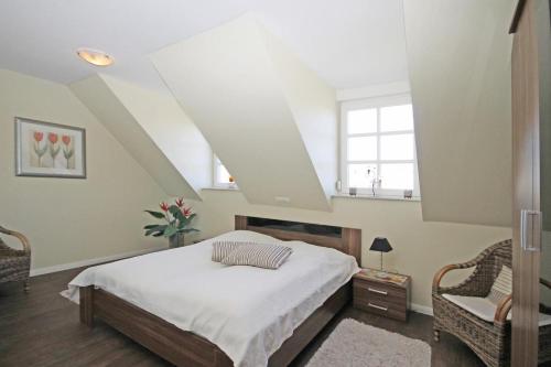 1 dormitorio con 1 cama y 2 ventanas en Villa Katharina en Kühlungsborn