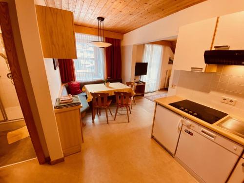 a kitchen with a table and a dining room at Apartments Residence Montana in Rasun di Sopra