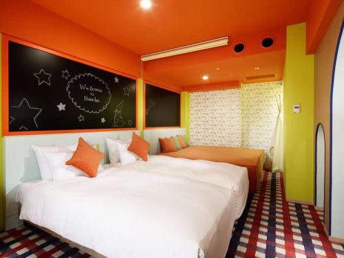 a bedroom with two beds and an orange wall at Naeba Prince Hotel in Yuzawa