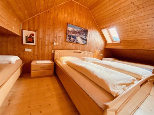 a bedroom with two beds in a wooden cabin at Apartments Residence Montana in Rasun di Sopra