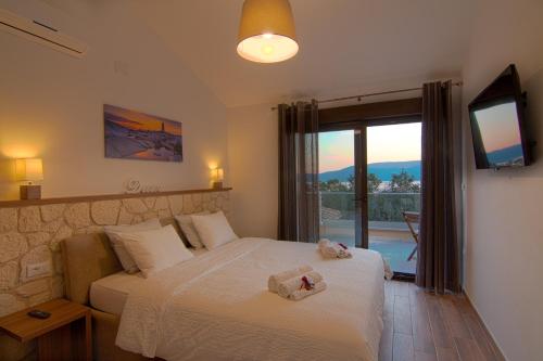 a bedroom with a bed with a television and a balcony at Modern villa with pool, sea view, near the sea and the beach - by Traveler tourist agency Krk ID 2168 in Pinezici
