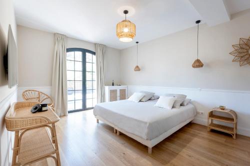 une chambre blanche avec un lit et une chaise dans l'établissement Somptueuse Villa sous les pins, à Lège-Cap-Ferret