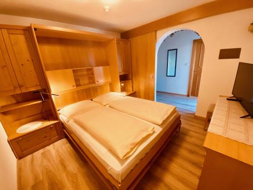 a bedroom with a large bed and a television at Apartments Residence Montana in Rasun di Sopra