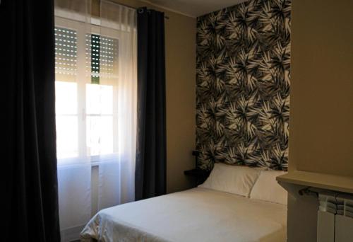 a bedroom with a bed and a window with a curtain at Guest House Prime Palace in Rome