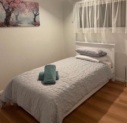 een slaapkamer met een bed met een groene handdoek erop bij 25 Wentworth Street shepparton in Shepparton