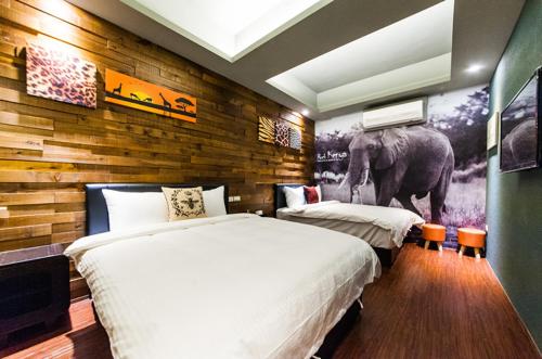 - une chambre avec 2 lits et une fresque murale représentant les éléphants dans l'établissement Superman, à Luodong