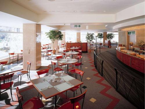 湯沢町にある苗場プリンスホテルのテーブルと椅子が備わるレストラン