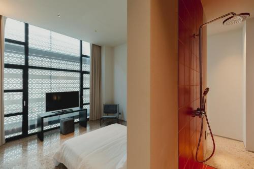 雅典的住宿－Plexi Space，一间卧室设有一张床、一台电视和一个窗口。