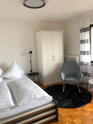 a bedroom with a bed and a chair and a cabinet at Apartment Leuchtberg Flair Eschwege in Eschwege