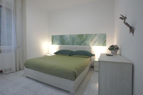 1 dormitorio con 1 cama y 1 mesa con 2 almohadas en Lago di Lecco - Parcheggio Gratuito - Stazione Ferroviaria, en Calolziocorte