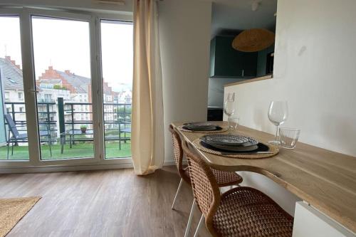 une salle à manger avec une table, des verres et une fenêtre dans l'établissement Appart Hôtel Lison - rénové 2023 Vieux Lille, à Lille