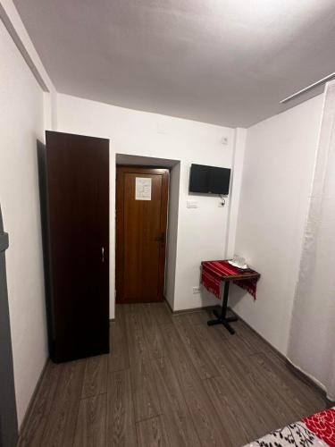 a room with a door and a table and a piano at Casa Bucovineană in Iaşi