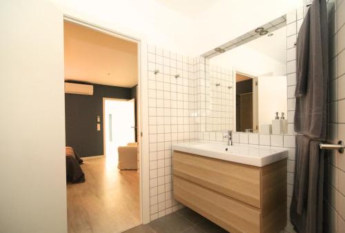 La salle de bains est pourvue d'un lavabo et d'un miroir. dans l'établissement Cozy apartment in Amazing Location!, à Lisbonne