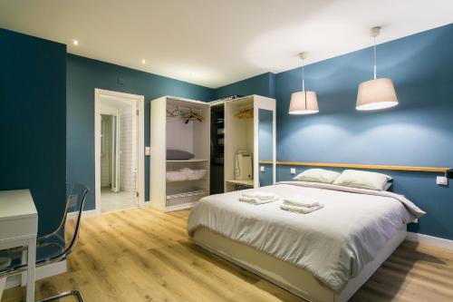 - une chambre avec des murs bleus, un lit et un bureau dans l'établissement Cozy apartment in Amazing Location!, à Lisbonne