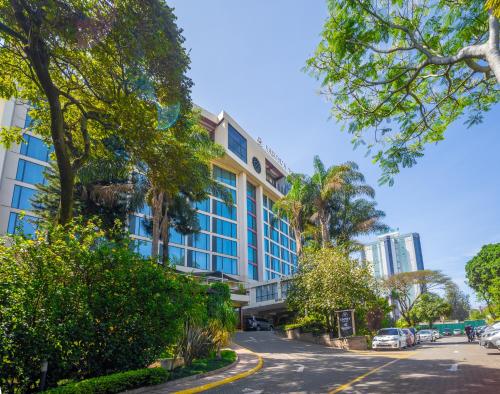 a building on the side of a street with trees at Sarova Panafric Hotel in Nairobi