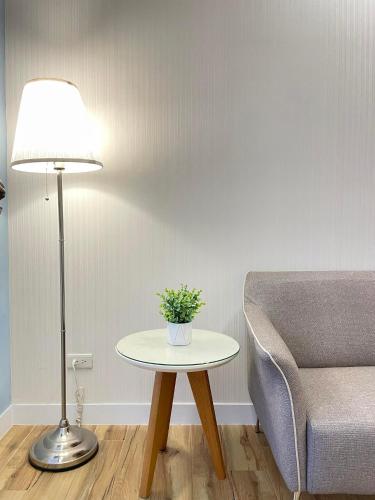 a living room with a table and a lamp and a couch at Joy Hotel in Taitung City