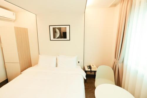 釜山にあるHotel Myeongjiのベッドが2つと鏡があるホテルの部屋
